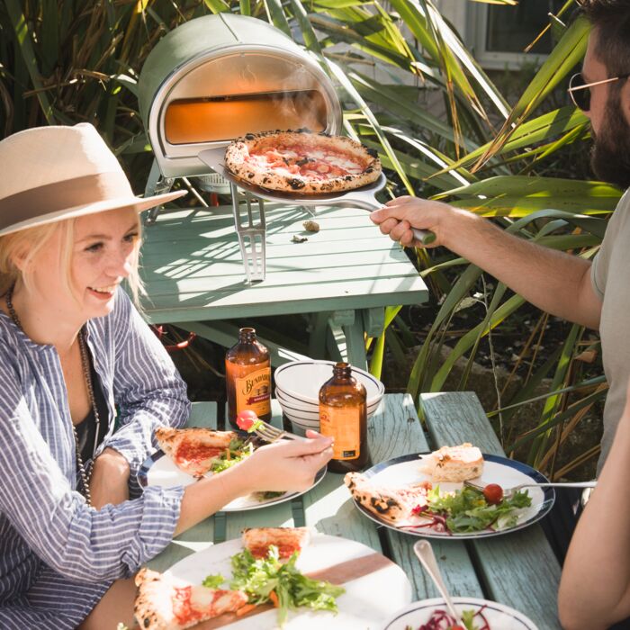 People eating pizza from a Roccbox