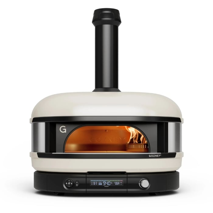 White and black gozney dome gen 2 pizza oven with visible flames inside, on a white background